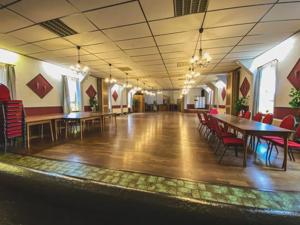 Festsaal mit roten Polsterstühlen und Kronleuchtern